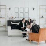 Three adults engaging in a professional discussion in a modern, elegantly decorated room.