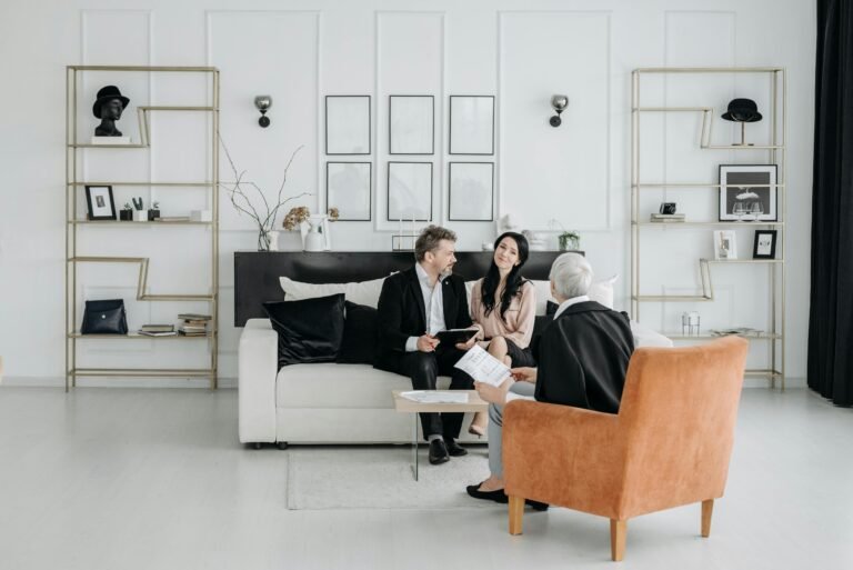 Three adults engaging in a professional discussion in a modern, elegantly decorated room.